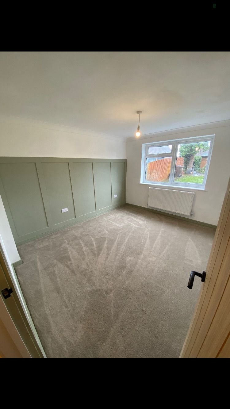 A bedroom with green wall panelling