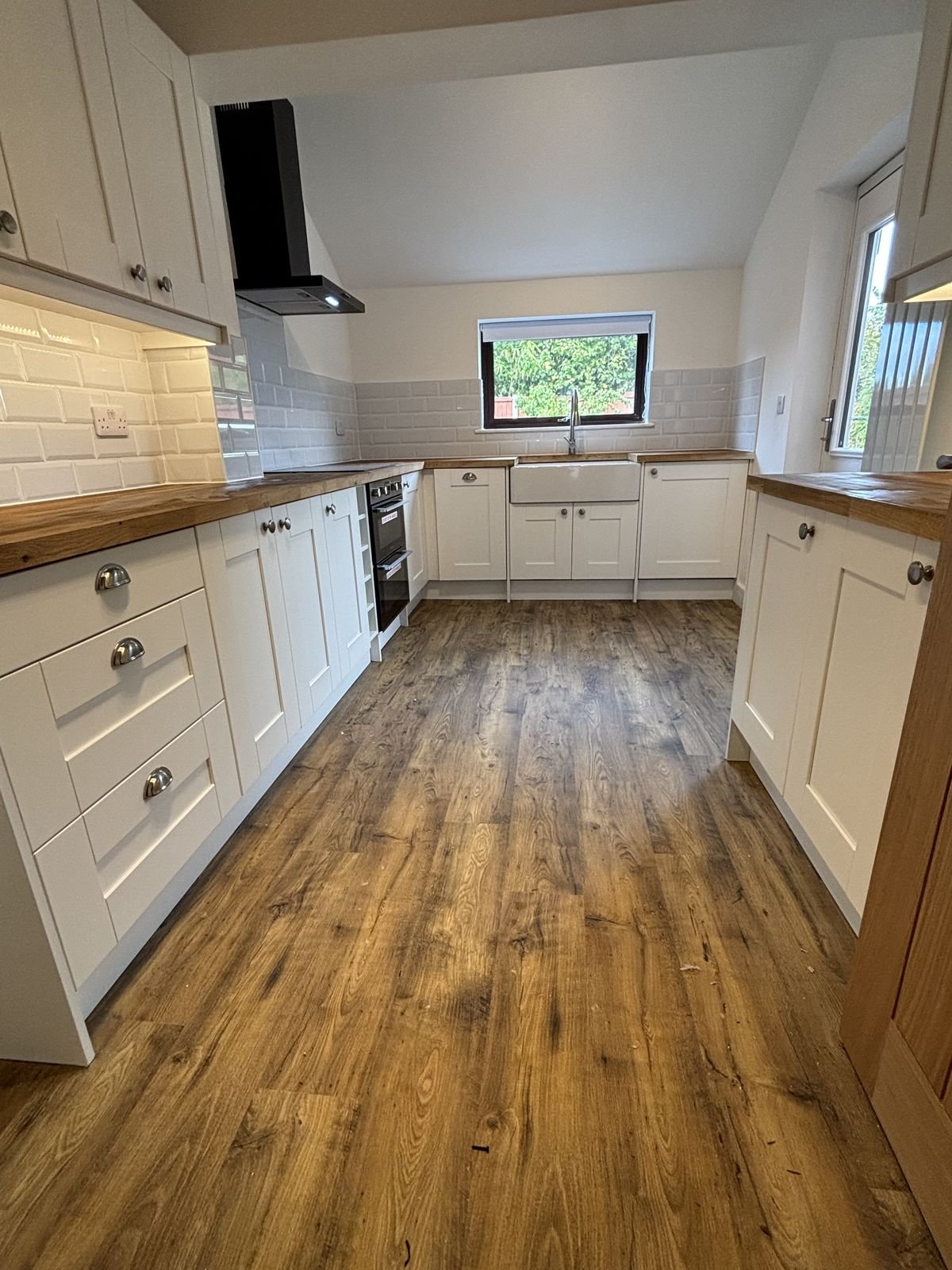 A shaker kitchen with rustic oak-effect flooring