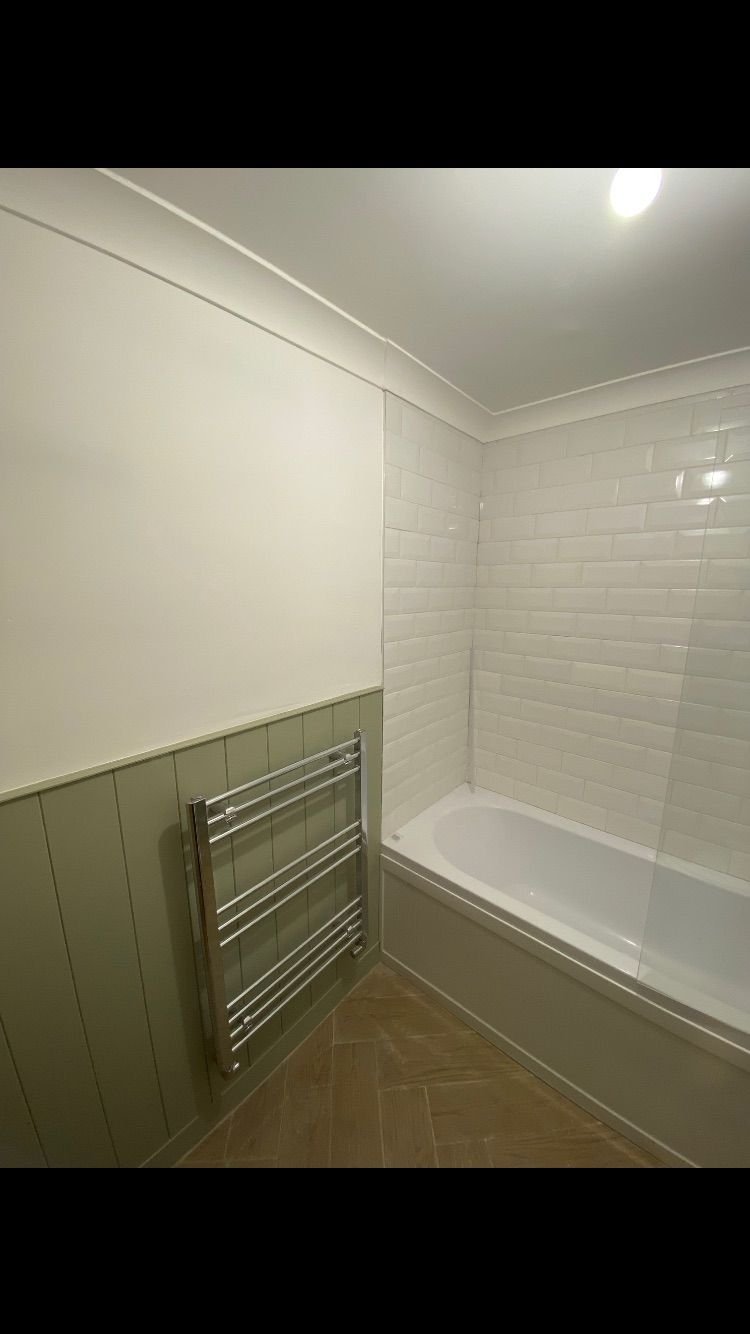 Sage panelling with a chrome towel rail