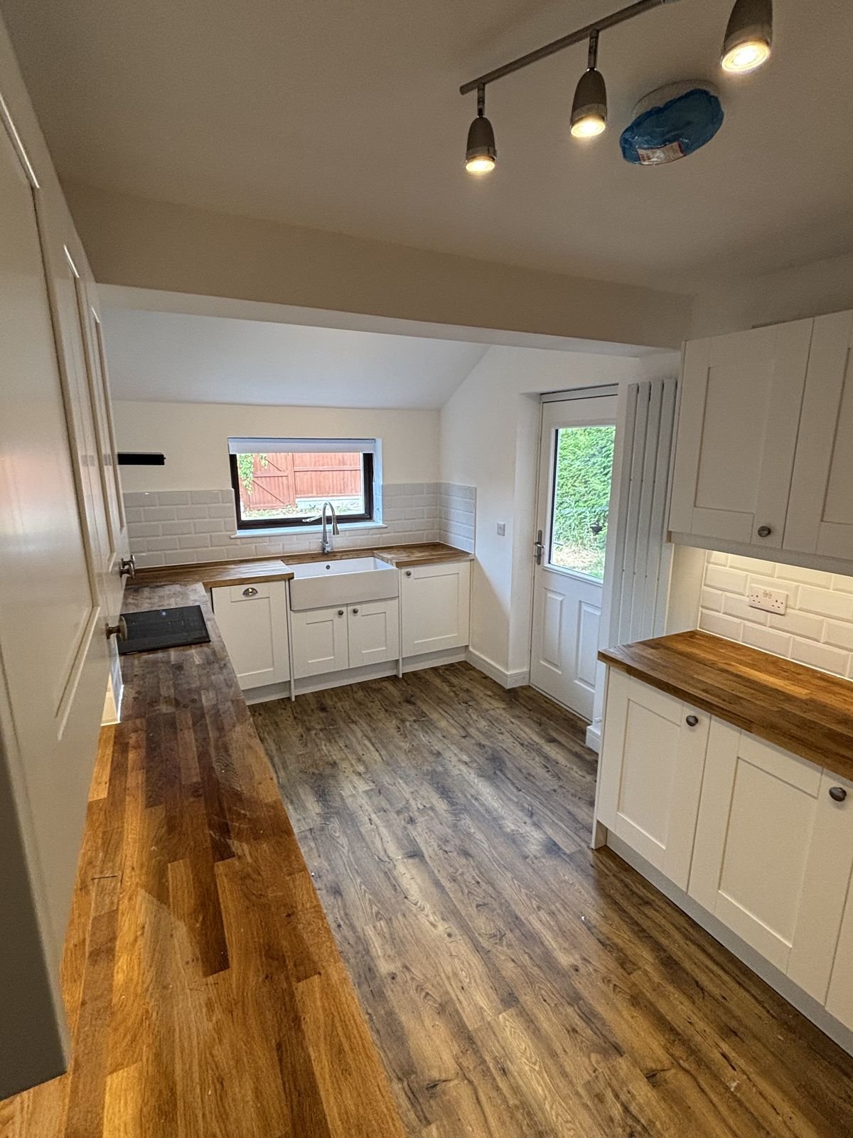 A galley kitchen with a Belfast sink and metro tiles