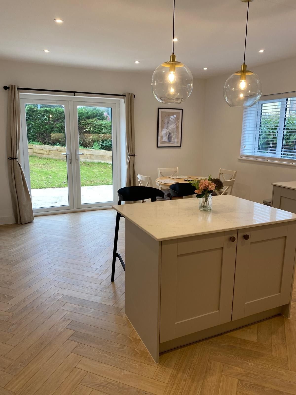 A kitchen with herringbone flooring and French doors