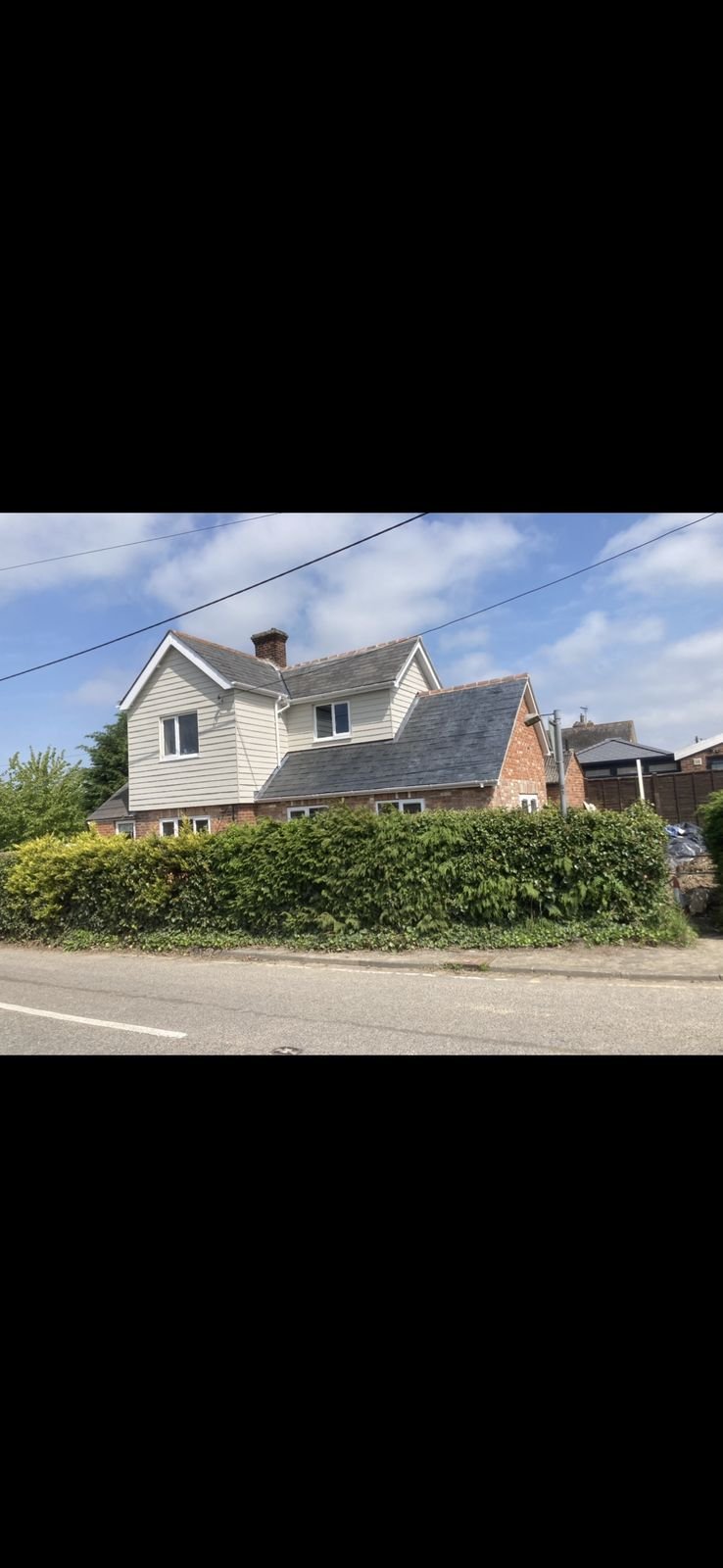 A finished house with cladding and a slate roof