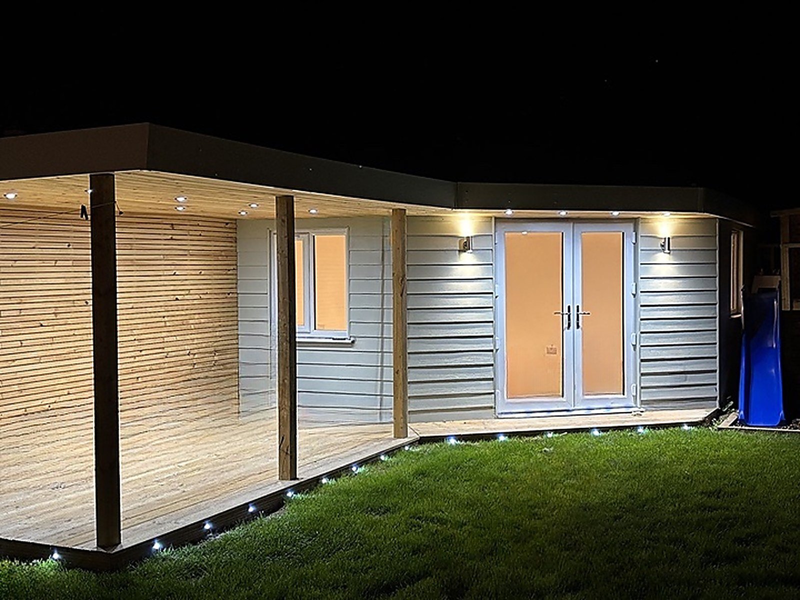 A garden room lit up at night