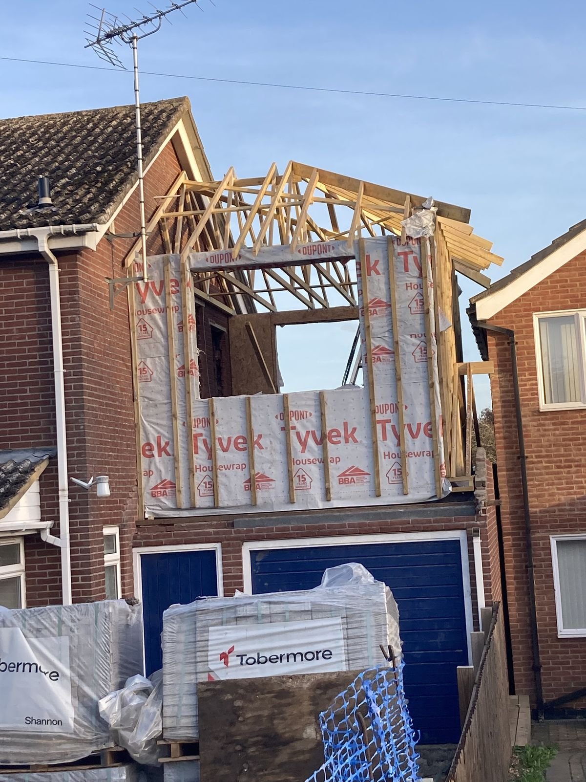 A timber frame above a garage wrapped in membrane