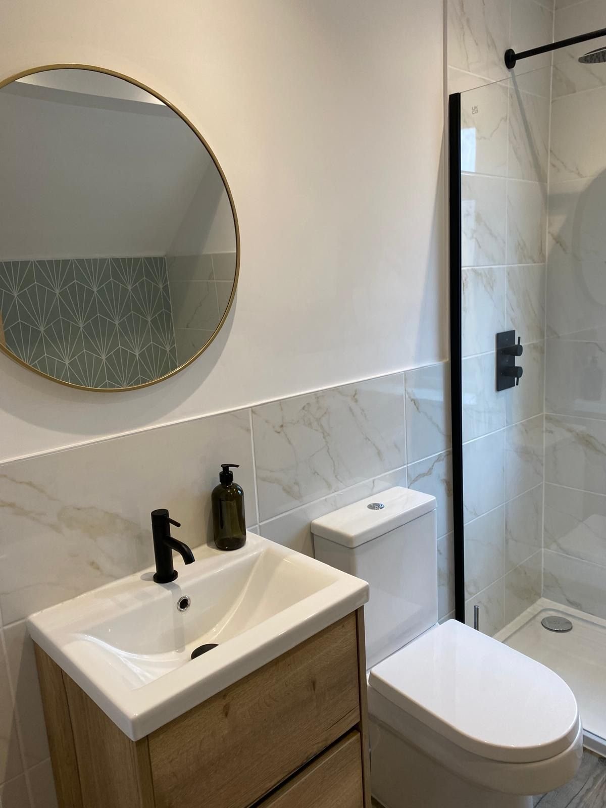 An en-suite with marble-effect tiles and an oak vanity